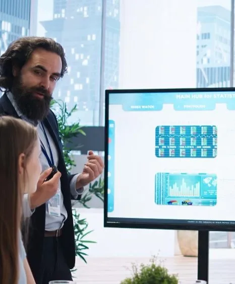 Presenter explaining a statistics dashboard on a large screen