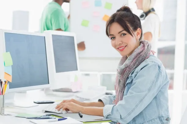 Smiling designer at a computer in a shared studio